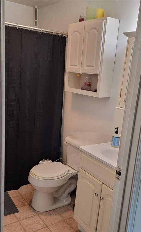 bathroom featuring vanity, tile patterned flooring, and toilet