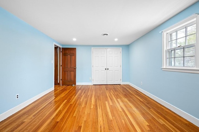 unfurnished bedroom featuring light wood-type flooring and a closet