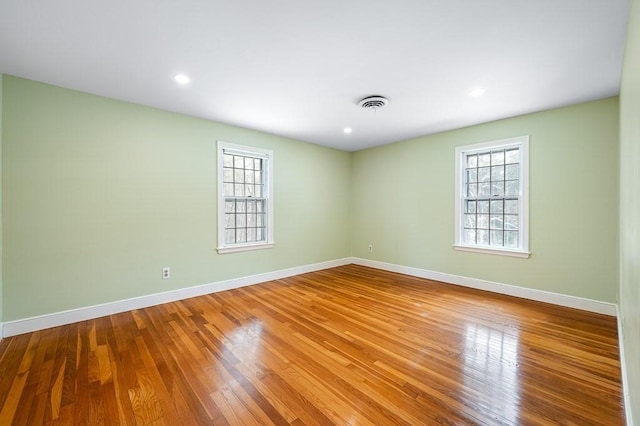 unfurnished room with wood-type flooring and a wealth of natural light