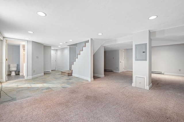 basement featuring a baseboard radiator, light carpet, and electric panel