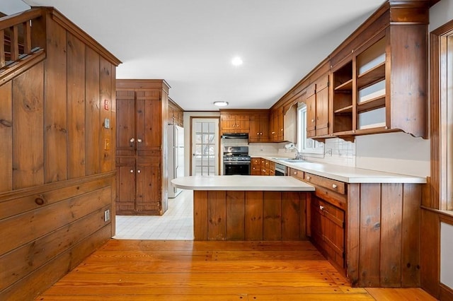 kitchen featuring sink, backsplash, white fridge, kitchen peninsula, and gas stove