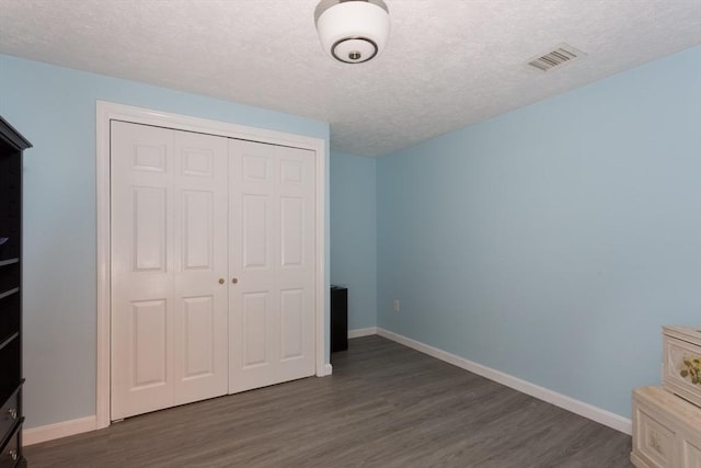 29 Benjamin Landing Ln Unit 29, Franklin, MA 02038 - unfurnished bedroom with dark wood finished floors, a textured ceiling, a closet, and baseboards