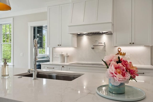 1 Beech Tree Ln, Lexington, MA 02421 - kitchen featuring backsplash, custom range hood, white cabinets, light stone countertops, and black electric cooktop