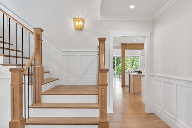 1 Beech Tree Ln, Lexington, MA 02421 - stairs featuring a decorative wall, ornamental molding, wood finished floors, a wainscoted wall, and recessed lighting