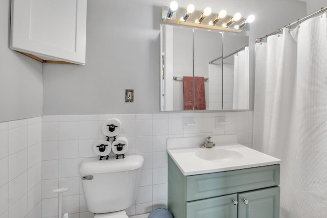 bathroom with vanity, curtained shower, toilet, and tile walls