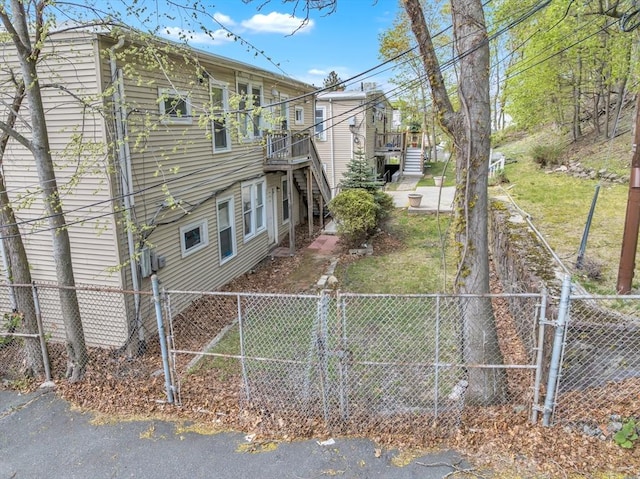 view of property exterior with a fenced backyard, a wooden deck, and stairs