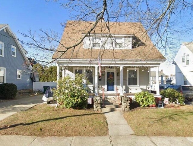 view of front of house with a porch and a front lawn