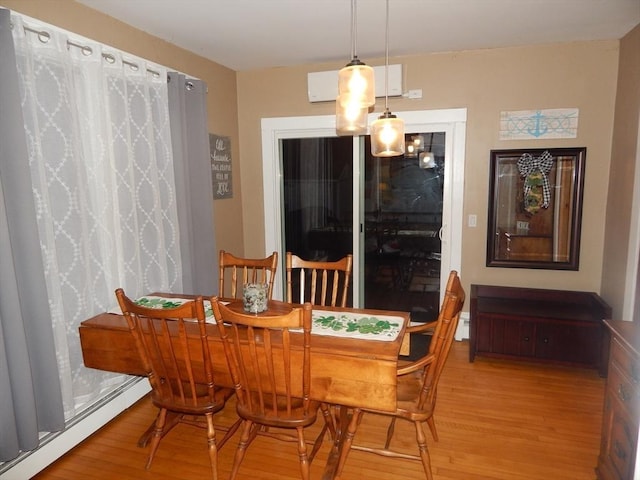 dining area featuring wood finished floors and a baseboard radiator