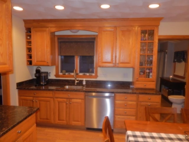 kitchen featuring dishwasher, dark stone counters, recessed lighting, and a sink