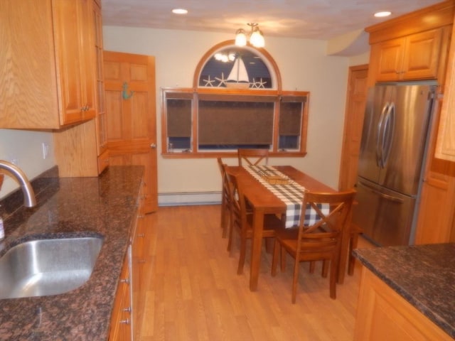 kitchen featuring light wood-type flooring, a sink, freestanding refrigerator, recessed lighting, and baseboard heating