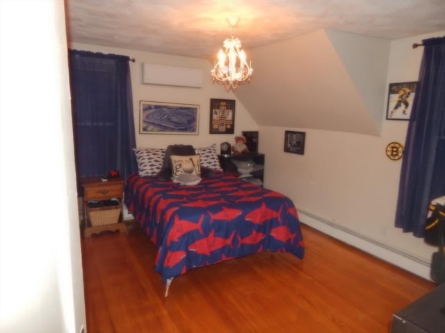 bedroom with an inviting chandelier, baseboard heating, wood finished floors, and lofted ceiling