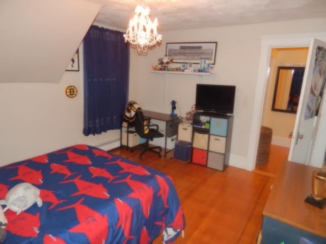 bedroom with baseboard heating, baseboards, an inviting chandelier, and wood finished floors