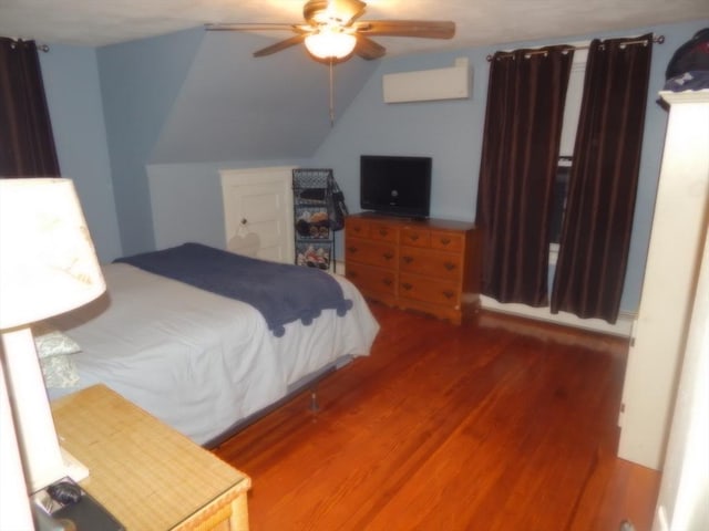 bedroom with ceiling fan, lofted ceiling, and wood finished floors