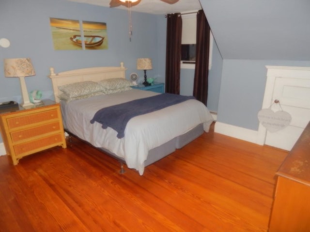 bedroom featuring vaulted ceiling, a ceiling fan, and wood finished floors