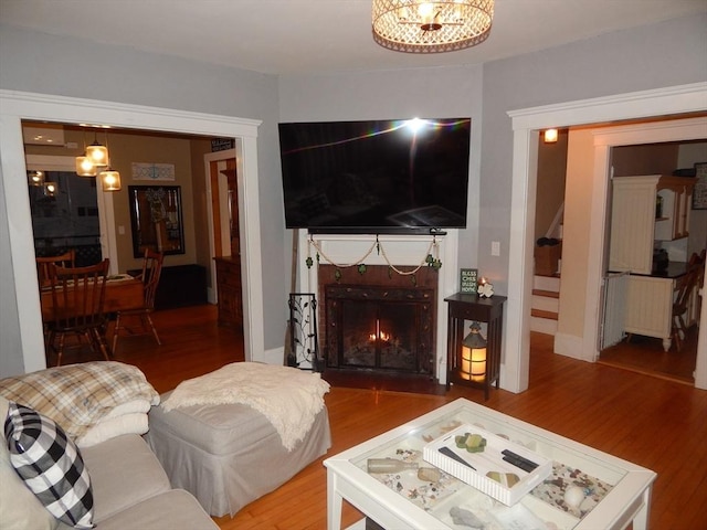 living area featuring a fireplace with flush hearth and wood finished floors