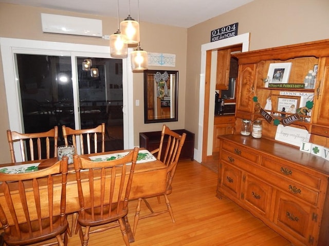 dining area featuring light wood-style flooring and an AC wall unit