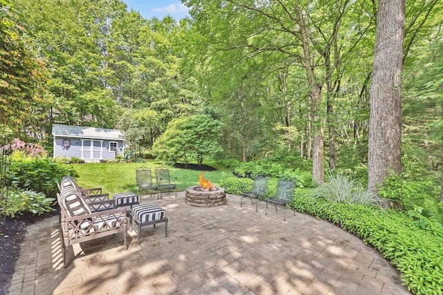 24 Azalea Way, Belchertown, MA 01007 - view of patio featuring a fire pit, an outbuilding, and a forest view