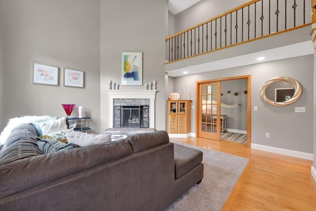 24 Azalea Way, Belchertown, MA 01007 - living room with light wood finished floors, a high ceiling, a fireplace, and french doors