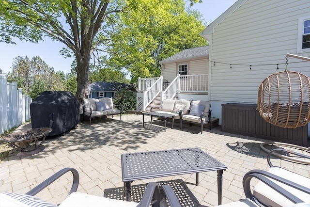 view of patio featuring outdoor lounge area, area for grilling, stairs, and fence