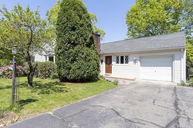 view of front of home with a chimney, a front yard, an attached garage, and roof with shingles