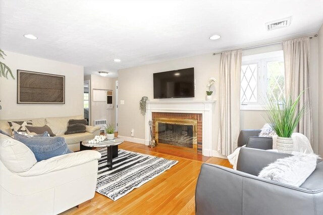 living room with wood finished floors, a fireplace, recessed lighting, and baseboards