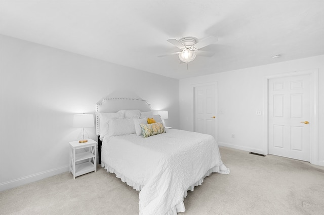 bedroom featuring light colored carpet, baseboards, and a ceiling fan