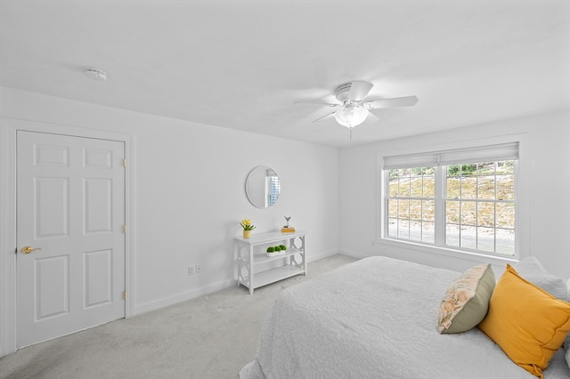 carpeted bedroom featuring baseboards and ceiling fan