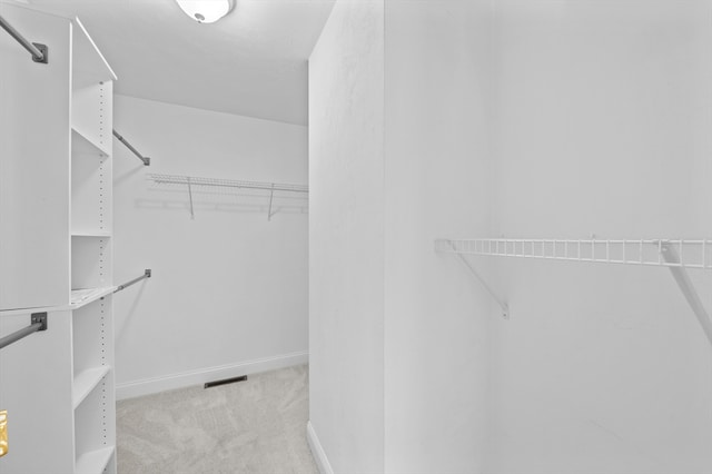 spacious closet featuring light carpet