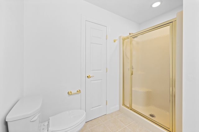 bathroom with toilet, tile patterned floors, and a shower stall