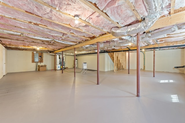 unfinished below grade area featuring electric panel and water heater