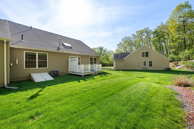 view of grassy yard featuring a wooden deck and central AC unit