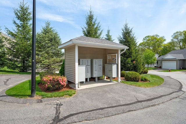 view of home's community with mail area and asphalt driveway