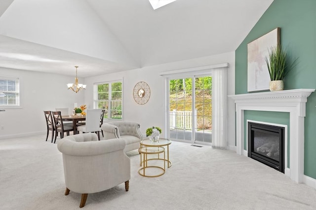 carpeted living area with a chandelier, baseboards, a glass covered fireplace, and high vaulted ceiling