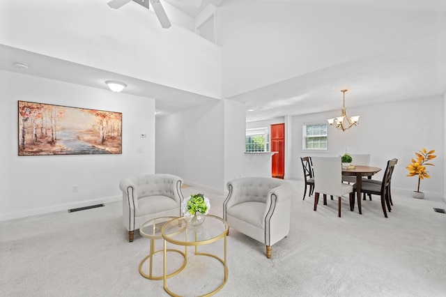carpeted living room featuring a chandelier, baseboards, and ceiling fan