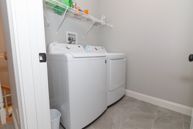 laundry area with light tile patterned floors and washing machine and dryer