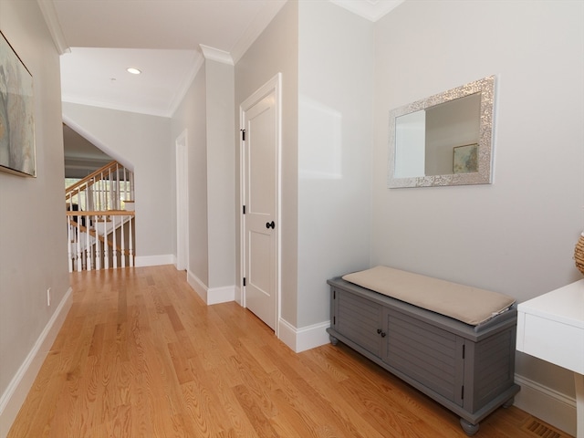 hall with ornamental molding and light hardwood / wood-style floors