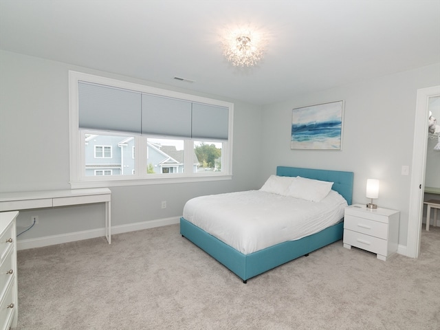 bedroom featuring multiple windows, a chandelier, and light colored carpet