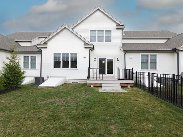 rear view of house featuring a lawn, central AC unit, and a deck