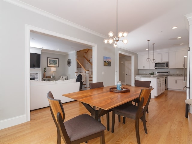 dining space featuring an inviting chandelier, light wood-type flooring, and crown molding