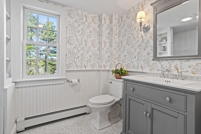 bathroom with a baseboard radiator, wainscoting, toilet, wallpapered walls, and vanity