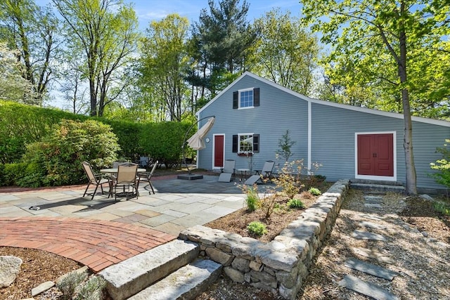 rear view of property featuring a patio and outdoor dining space