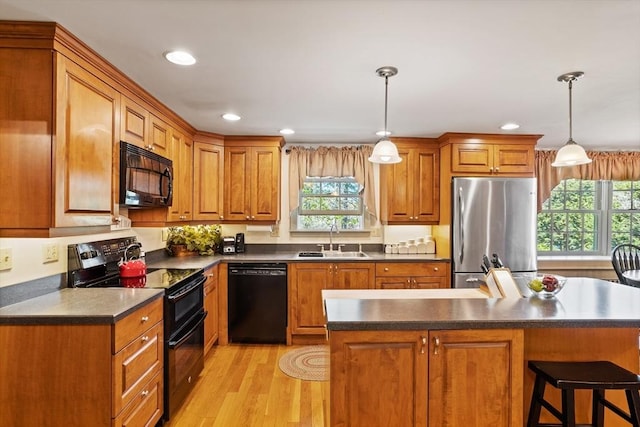 kitchen with black appliances, a sink, healthy amount of natural light, dark countertops, and recessed lighting