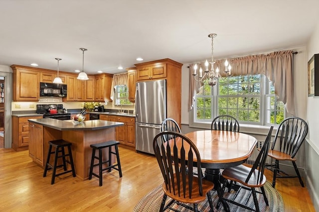 dining space with a chandelier, light wood-style floors, and recessed lighting
