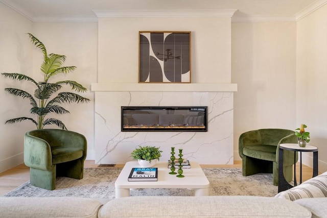 living room featuring crown molding, a fireplace, and light hardwood / wood-style flooring