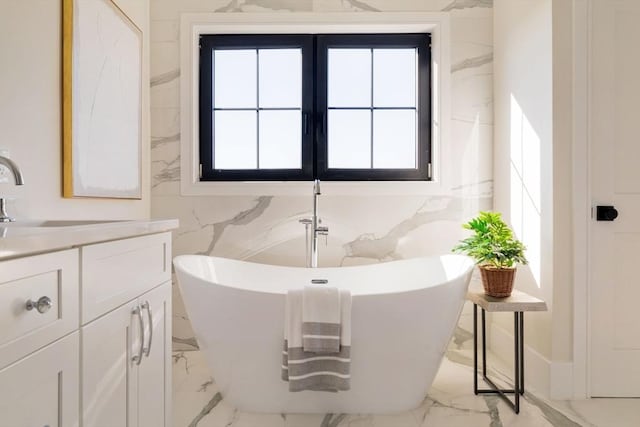 bathroom featuring a bath, vanity, and a wealth of natural light