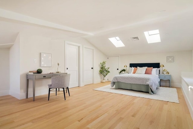 bedroom with light wood-type flooring and lofted ceiling with skylight