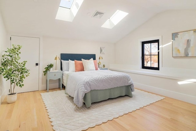 bedroom featuring hardwood / wood-style flooring and vaulted ceiling with skylight