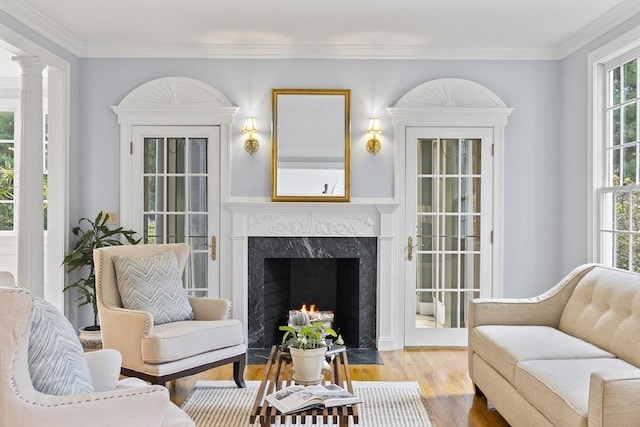 living area featuring wood finished floors, a premium fireplace, and crown molding