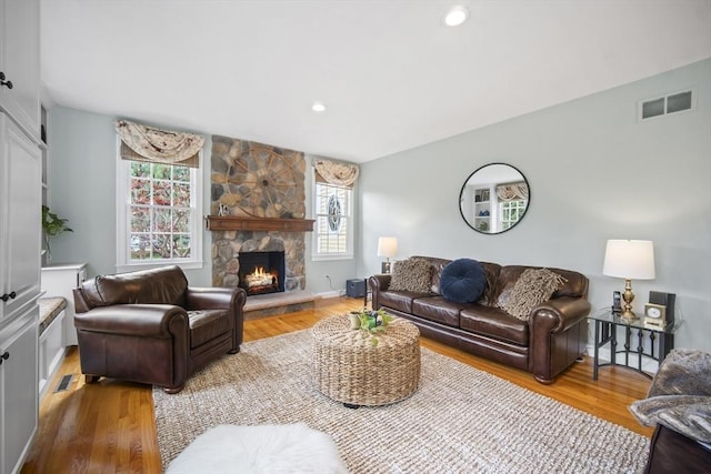 living room featuring wood finished floors, a fireplace, and recessed lighting