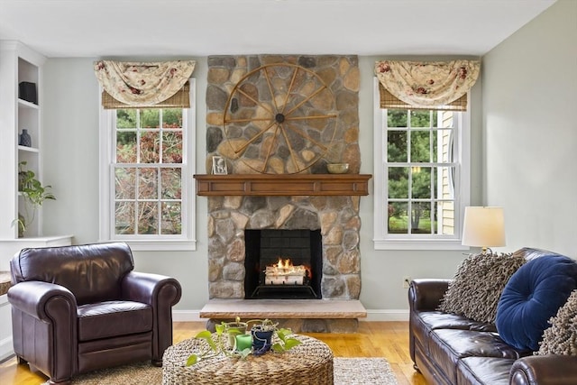 living room with wood finished floors, a fireplace, and baseboards